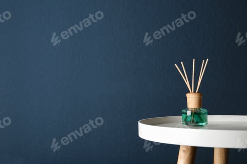 Preview: Reed air freshener on table against dark blue background, space for text