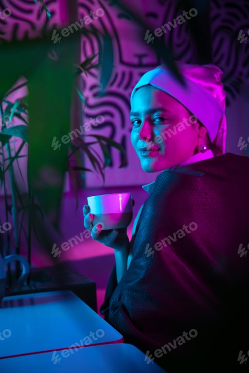 Preview: Beautiful girl with a pearl earring taking lunch in modern cafe, restaurant in neon light