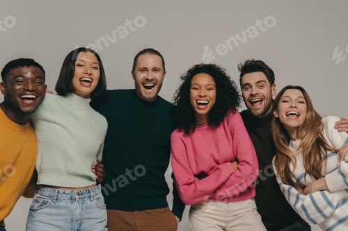 Preview: Joyful young people bonding and smiling while standing on beige background together