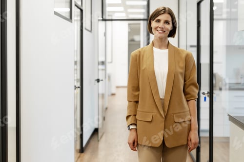 Preview: Businesswoman smiling in modern office corridor