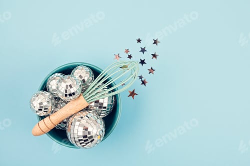 Preview: Flat lay with disco balls in the bowl with whisk. Party, fun, celebration planning