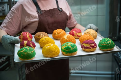 Preview: Close-up woman confectioner holding baking sheet with fresh and crispy cookies