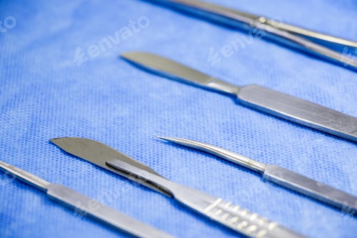 Preview: Top view of medical scalpels on a blue fabric surface