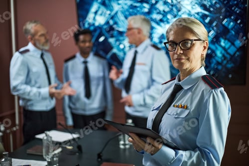 Preview: Senior Woman Politician Holding Tablet While Colleagues Discussing Strategy