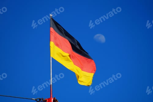 Preview: The German flag flying against a blue sky with the moon in the background