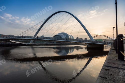Preview: A serene sunset over a modern arched bridge with reflections in calm water