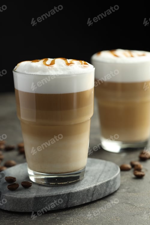 Preview: Tasty latte macchiato in glasses and coffee beans on grey table, closeup