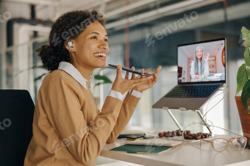 Preview: Female freelancer have video conference with client and record audio message sitting in coworking
