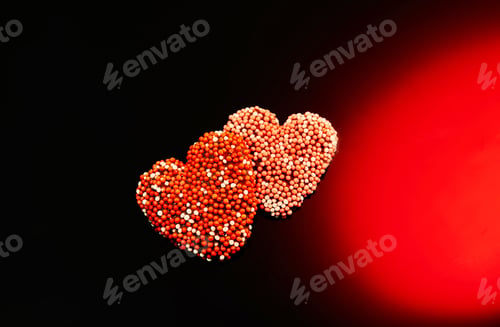 Preview: Valentine's Day candies on red black background. Red candy hearts with space for text