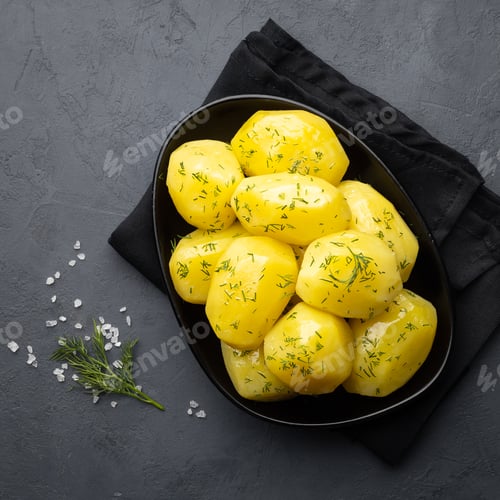 Preview: Delicious boiled potatoes with dill in a black plate.