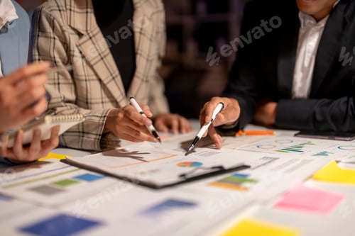 Preview: Three people are sitting at a table with papers and pens