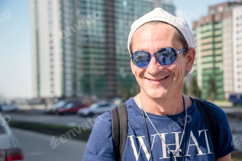 Preview: ↟ Portrait of an adult man in a summer T-shirt and glasses on a bright sunny day outside