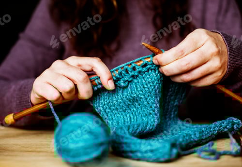 Preview: Woman Knitting Teal Fabric on Wooden Table