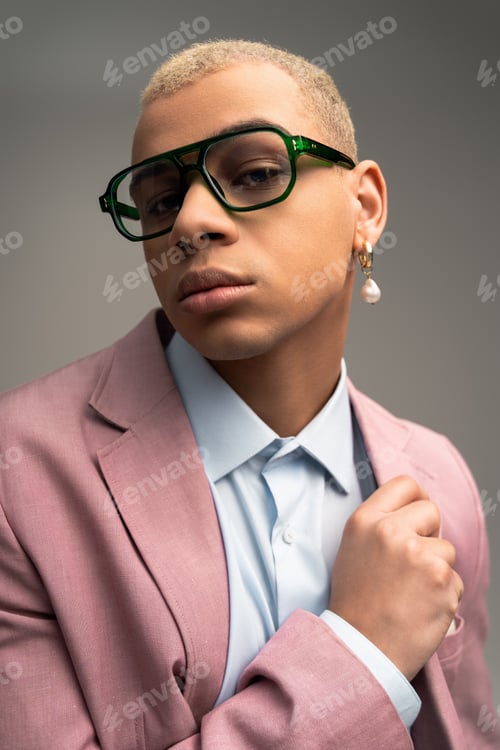 Preview: Stylish man exudes confidence in trendy attire and bold accessories in studio setting
