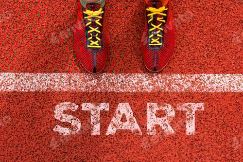 Preview: A runner is positioned at the starting line, wearing red shoes, ready for a race on the track