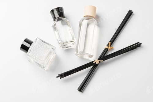 Preview: Elegant arrangement of essential oil diffusers with reeds and glass bottles on a minimalist surface