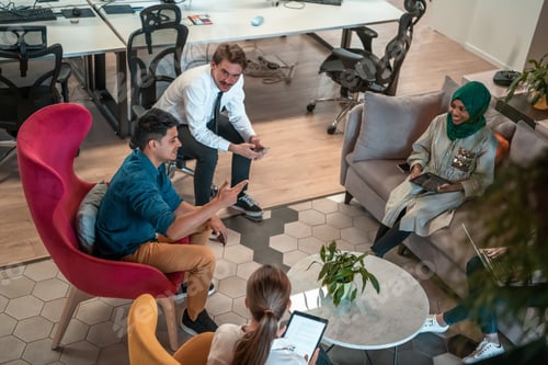 Preview: Multiethnic startup business team having brainstorming in relaxation area of modern office interior