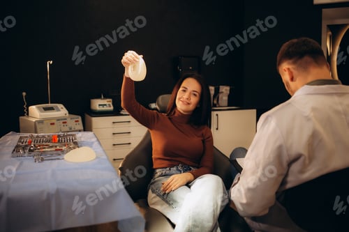 Preview: woman chooses a breast implant in the plastic surgeon's office