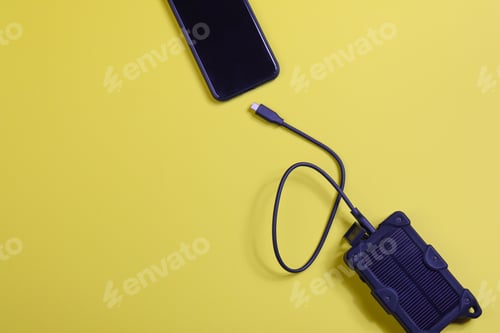 Preview: cheapest source of electricity. power box, portable solar battery for phone on yellow background.