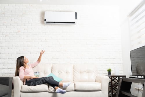 Preview: Woman Turning on Air Conditioner At Home