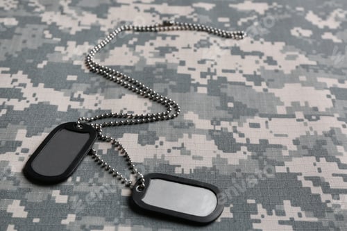 Preview: Metal military ID tags on camouflage background. Space for text