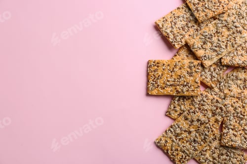 Preview: Delicious crackers on pink background, flat lay. Space for text