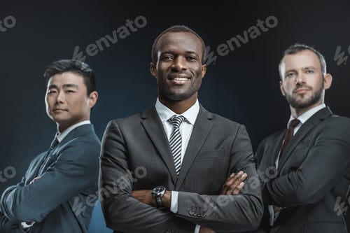 Preview: portrait of multicultural group of businessmen in suits looking at camera isolated on black