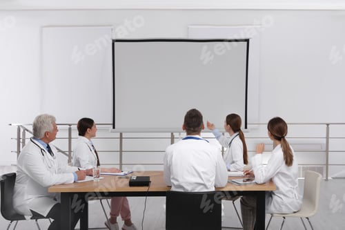 Preview: Team of doctors using video projector during conference indoors