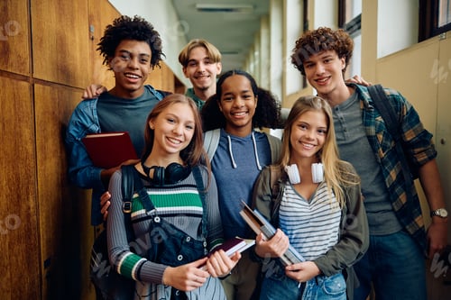 Preview: Multiracial group of happy teenage friends at high school looking at camera.