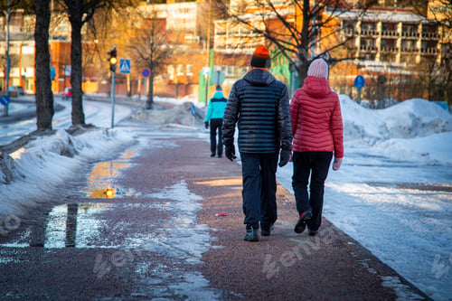 Preview: People wearing winter clothing walking on a snowy, frosty street