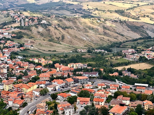 Preview: Abstract Geometric Pattern From House Roofs With Orange Red Colored Shingle With Road In San Marino