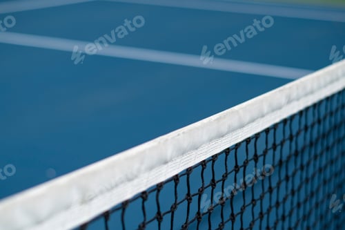 Preview: Closeup of a tennis net on the court on a sunny day with a blurry background