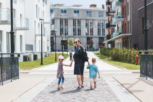 Preview: Young mother with two kids walking around the city