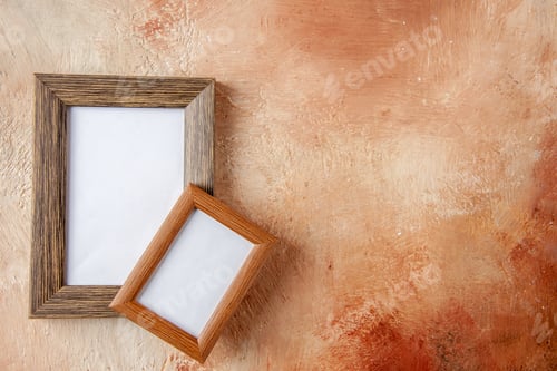 Preview: Front view of brown wooden photo frames on the right side in different sizes hung on top of each