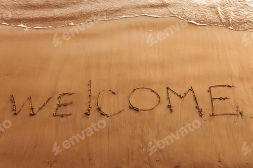 Preview: Hand drawn message Welcome on wet yellow sand on beach of sea