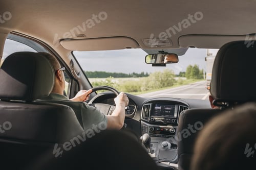 Preview: Young man holding steering wheel while driving car. Road trip adventure