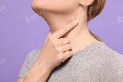 Preview: Woman suffering from sore throat on violet background, closeup