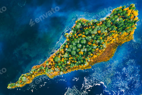 Preview: Aerial drone view of colorful tree woods island in blue lake or sea in fall season Finland.