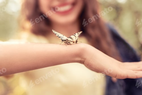 Preview: Butterfly sitting on arms of woman