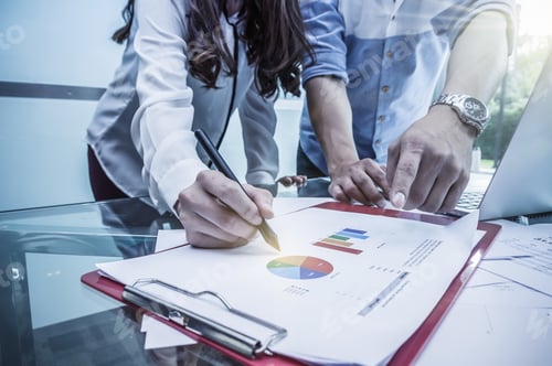 Preview: Business documents with laptop on the workplace with group of business teamwork working