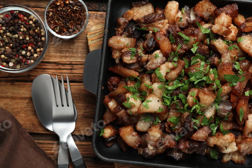 Preview: Tasty fried cracklings on wooden table, flat lay. Cooked pork lard