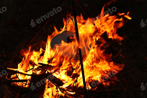 Preview: Cooking outdoors in field conditions. Cauldron on a fire in the forest. Cooking at the stake while