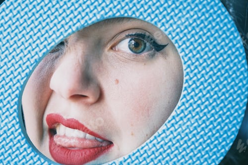 Preview: Pretty young woman face behind a blue circle