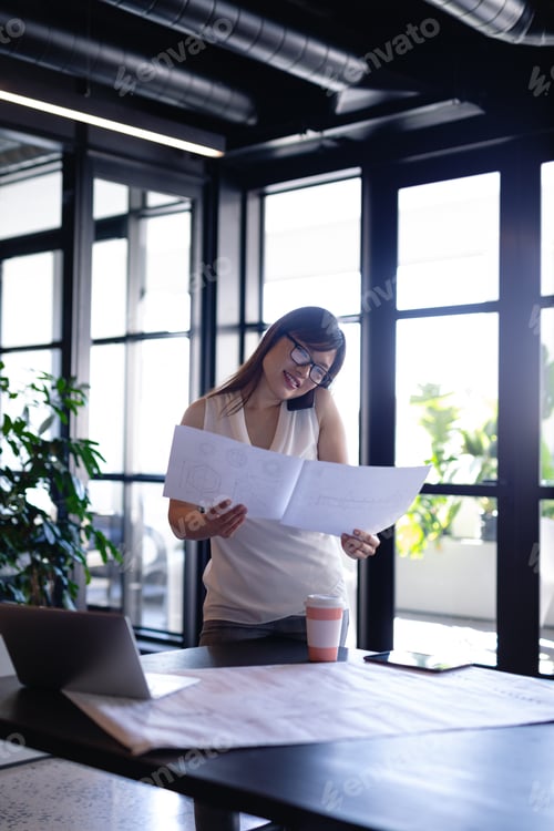 Preview: Asian woman having a business phone call in her office