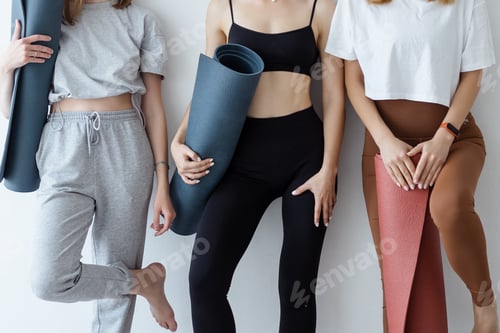 Preview: A group of young sports girls standing against a wall.
