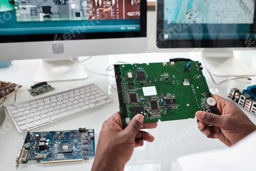 Preview: Hands of young African scientist holding part of electronic device