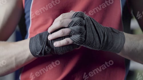 Preview: Man flexing his fists before a fight. Close-up of a young Thai boxer hands hemp ropes are wrapped