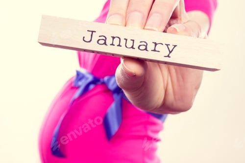 Preview: Pregnant woman in pink dress with blue ribbon showing word january