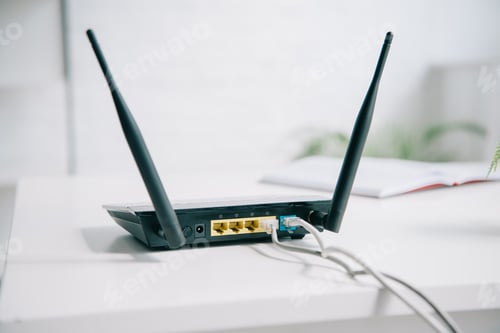 Preview: black plugged router on office table in sunshine