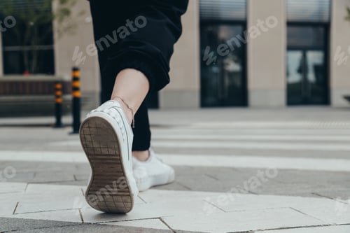 Preview: Legs of a girl in White Leather Sneakers Crosses the Street on a Pedestrian Crossing
